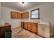 A view of a kitchen with wooden cabinets, white countertops, and worn flooring at 2921 Ambrose Dr, Gastonia, NC 28056