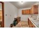 A view of a kitchen with wooden cabinets, white countertops, and worn flooring at 2921 Ambrose Dr, Gastonia, NC 28056