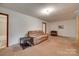 A sparsely decorated living room with a couch, unfinished floors, and connections to other rooms at 2921 Ambrose Dr, Gastonia, NC 28056