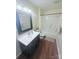 Well-lit bathroom featuring wood floors, shower/tub combo, and vanity with dark wood cabinets at 300 N Watterson St, Kings Mountain, NC 28086