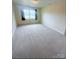 Bright bedroom with neutral walls, plush carpet, and a window offering natural light at 300 N Watterson St, Kings Mountain, NC 28086