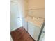 Functional laundry area with washer, dryer, laminate flooring, and convenient shelving at 300 N Watterson St, Kings Mountain, NC 28086