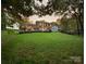 Large backyard with string lights illuminating a well-manicured lawn, deck, and outdoor seating areas at 3314 Mara Ct, Matthews, NC 28105