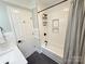 Bright bathroom featuring a tub with white tile, a shower niche, and sleek, dark hardware at 3314 Mara Ct, Matthews, NC 28105