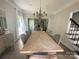 Dining area featuring a herringbone table, seating for eight, a chandelier and natural light pouring in from the large window at 3314 Mara Ct, Matthews, NC 28105