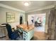 Bright office space with hardwood floors, an artful wall, and natural light pouring in from the adjacent dining area at 3314 Mara Ct, Matthews, NC 28105