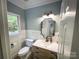 Charming powder room with paneled walls, a decorative mirror, and a wood-toned vanity with a marble countertop at 3314 Mara Ct, Matthews, NC 28105