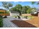 Outdoor firepit with Adirondack chairs and a detached garage nestled in the beautifully landscaped backyard at 343 Melbourne Ct, Charlotte, NC 28209