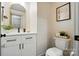 Stylish powder room featuring patterned wallpaper, a vanity sink, and gold accents at 343 Melbourne Ct, Charlotte, NC 28209