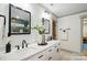 Bright bathroom featuring a double vanity with white cabinets, quartz countertop and framed mirrors at 343 Melbourne Ct, Charlotte, NC 28209
