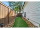 Narrow, well-maintained side yard featuring gravel, pavers, turf and a privacy fence at 343 Melbourne Ct, Charlotte, NC 28209