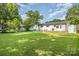 Large backyard with lush green lawn, patio, storage shed, and privacy fence at 3615 Kempton Pl, Charlotte, NC 28208