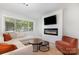 Inviting living room showcasing a modern fireplace, large window, and comfortable seating area at 3615 Kempton Pl, Charlotte, NC 28208