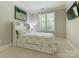 Cozy bedroom with neutral tones, a window providing natural light, and a mounted TV at 4026 Barclay Downs Dr, Charlotte, NC 28209