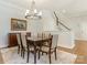 Dining room features hardwood floors, a modern chandelier, and staircase access at 4026 Barclay Downs Dr, Charlotte, NC 28209