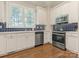 Well-lit kitchen with white cabinets, stainless steel appliances, and blue tile backsplash at 4026 Barclay Downs Dr, Charlotte, NC 28209