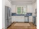 Well-lit kitchen with white cabinets, stainless steel appliances, and a blue tiled backsplash at 4026 Barclay Downs Dr, Charlotte, NC 28209