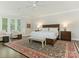 Spacious main bedroom with a king-sized bed, a large bay window, and a cozy sitting area at 4026 Barclay Downs Dr, Charlotte, NC 28209
