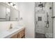 Modern bathroom featuring a sleek vanity with marble countertop and a glass-enclosed shower with geometric tile at 411 Granby Cir, Charlotte, NC 28217