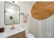 Stylish bathroom featuring modern fixtures, a unique patterned wall, and a well-lit mirror at 411 Granby Cir, Charlotte, NC 28217