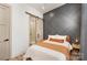 Comfortable bedroom with accent wall and sliding door to the bathroom at 411 Granby Cir, Charlotte, NC 28217