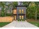 Modern two-story home featuring a gray facade, natural wood accents, and a charming fenced yard at 411 Granby Cir, Charlotte, NC 28217