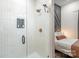 Modern shower with geometric tiles, rainfall showerhead, and a glass door, with a view into the bedroom at 411 Granby Cir, Charlotte, NC 28217