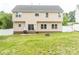 View of backyard featuring level lawn, partial white fence, patio, and fire pit, showcasing the home's exterior at 435 Riverwalk Nw Dv, Concord, NC 28027