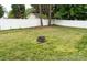 Spacious backyard featuring a fire pit, tall mature trees, and a white picket fence at 435 Riverwalk Nw Dv, Concord, NC 28027