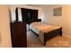 Cozy bedroom features neutral walls, a bed with a brown frame, and a dark wood dresser at 435 Riverwalk Nw Dv, Concord, NC 28027