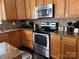 Well-equipped kitchen with stainless steel appliances, granite countertops, and an abundance of wooden cabinets at 435 Riverwalk Nw Dv, Concord, NC 28027