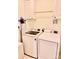 Bright laundry room with white washer, dryer, cabinets, and hanging rack at 435 Riverwalk Nw Dv, Concord, NC 28027