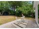Backyard patio with outdoor seating surrounded by mature trees and lush landscaping at 4562 Rockford Ct, Charlotte, NC 28209