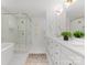 Bright bathroom featuring a double sink vanity, soaking tub, and glass-enclosed shower at 4562 Rockford Ct, Charlotte, NC 28209