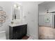 Modern bathroom with sleek vanity, backlit mirror, black hardware, and access to another room, offering style and convenience at 4562 Rockford Ct, Charlotte, NC 28209