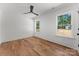 Cozy and well-lit bedroom with neutral walls, hardwood floors, a modern ceiling fan, and two bright windows at 4562 Rockford Ct, Charlotte, NC 28209