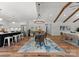 Open concept dining room featuring a modern chandelier, exposed beams, and seamless flow into the kitchen and living area at 4562 Rockford Ct, Charlotte, NC 28209