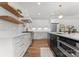 Modern kitchen featuring custom white cabinetry, hardwood floors, a stainless steel range, and floating shelves at 4562 Rockford Ct, Charlotte, NC 28209
