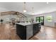 Modern, open kitchen with a large island, stainless steel appliances, and hardwood floors overlooking a dining and living area at 4562 Rockford Ct, Charlotte, NC 28209