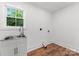 Functional laundry room area with a stainless steel sink, ample natural light from the window, and hookups for appliances at 4562 Rockford Ct, Charlotte, NC 28209