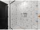Modern shower with geometric tiles, glass enclosure, matte black trim, and a convenient in-shower niche for storage at 4562 Rockford Ct, Charlotte, NC 28209