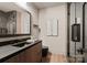 Modern bathroom showcasing sleek vanity with dark fixtures, an elegant mirror, and a glass-enclosed shower at 5432 Carmel Rd, Charlotte, NC 28210