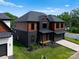Eye-level view of a modern house with black and wood exterior and large driveway at 5432 Carmel Rd, Charlotte, NC 28210