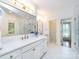 Bright bathroom with dual sinks, gold fixtures, and a walk-in shower and private toilet at 5816 Valley Stream Trl, Waxhaw, NC 28173