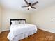 Comfortable bedroom with hardwood floors, a ceiling fan, and plantation shutters at 5816 Valley Stream Trl, Waxhaw, NC 28173