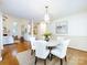Open dining room with modern chandelier, white chairs, and views to the living room at 5816 Valley Stream Trl, Waxhaw, NC 28173