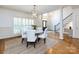 Elegant dining room with modern chandelier, white chairs, and open view to the foyer and staircase at 5816 Valley Stream Trl, Waxhaw, NC 28173