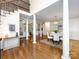 Open-concept dining area with hardwood floors, white columns, and view of staircase and living area at 5816 Valley Stream Trl, Waxhaw, NC 28173