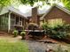 A brick home features a screened in porch and small deck leading to the backyard at 5816 Valley Stream Trl, Waxhaw, NC 28173