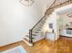 Bright entryway with hardwood floors, staircase with iron spindles, and views into the living spaces at 5816 Valley Stream Trl, Waxhaw, NC 28173